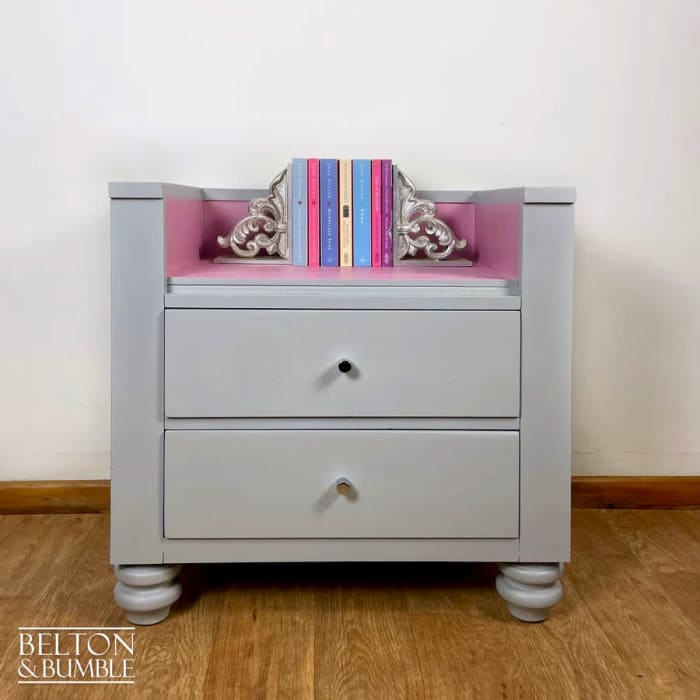 Bookcase detail showing painted pink drawers and storage compartments