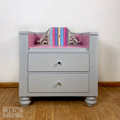 Bookcase detail showing painted pink drawers and storage compartments