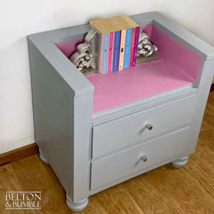 Top of storage drawers on chair and bookcase for children’s books and toys