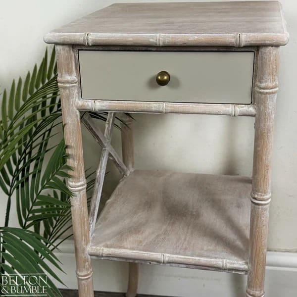 Drawer detail of faux bamboo bedside table with aged brass knob
