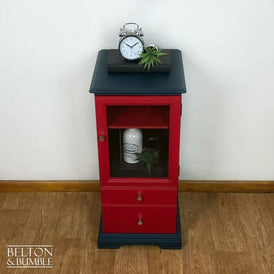 Blue and red vintage drinks cabinet with glass door shown from angled perspective, hand painted finish