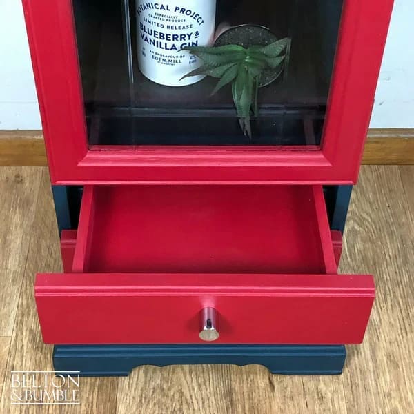 Interior of vintage glass door drinks cabinet showing bottom drawer for versatile storage