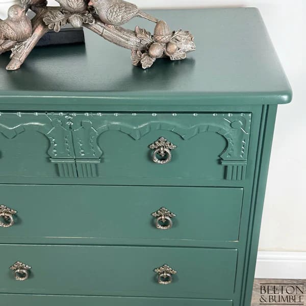 Close-up of ornate carved detailing on hand-painted jewel green chest of drawers