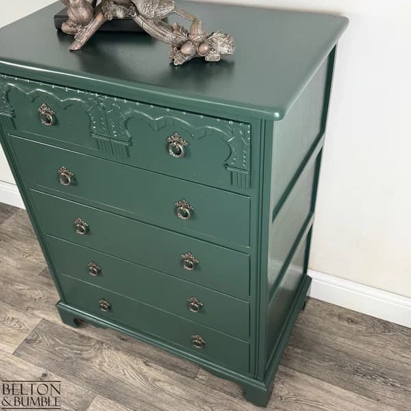 Angled view showing hand-painted jewel green chest of drawers with carved detailing