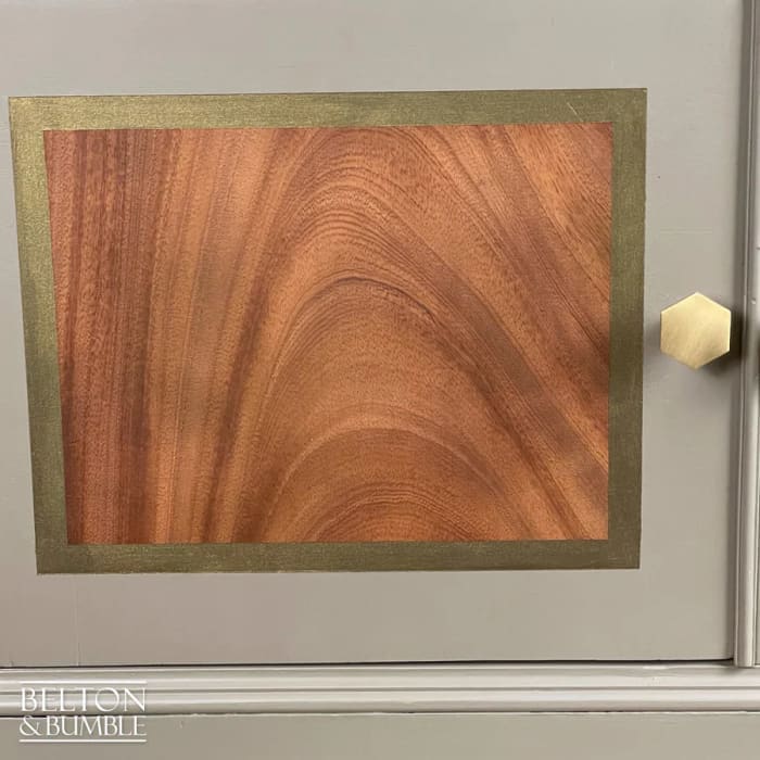 Close-up of bronze detailing on mahogany cocktail cabinet door