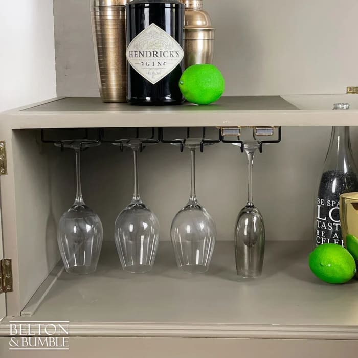 Black metal hanging wine glass rack inside mahogany cocktail cabinet