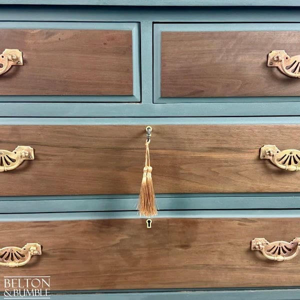 Close-up of mahogany and walnut grain on vintage chest of drawers drawer front