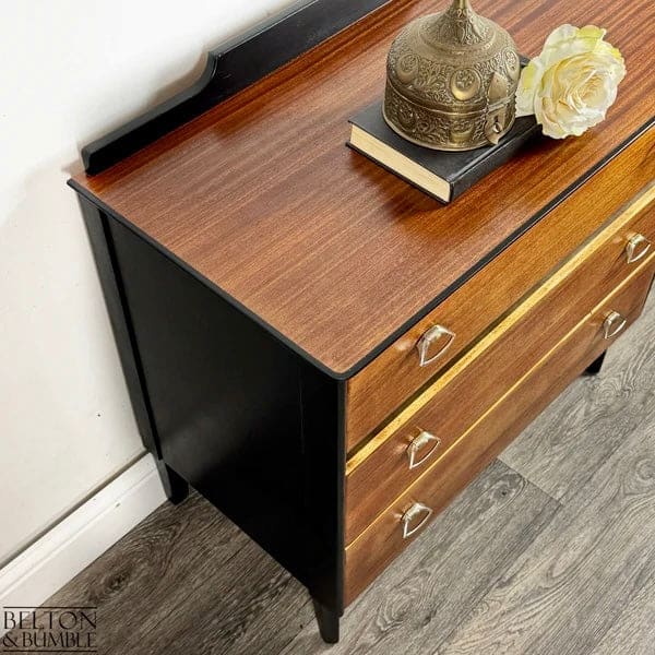 Side profile of hand-painted mid-century modern chest of drawers in jet black with teak drawer fronts