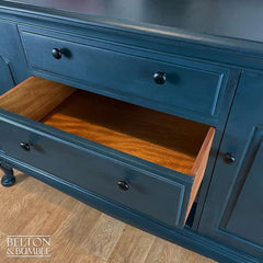 Close-up of dovetail drawers and black pulls on hand-painted teal sideboard
