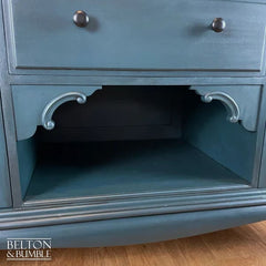 Detail of carved fleur de lis on dark teal hand-painted solid wood sideboard